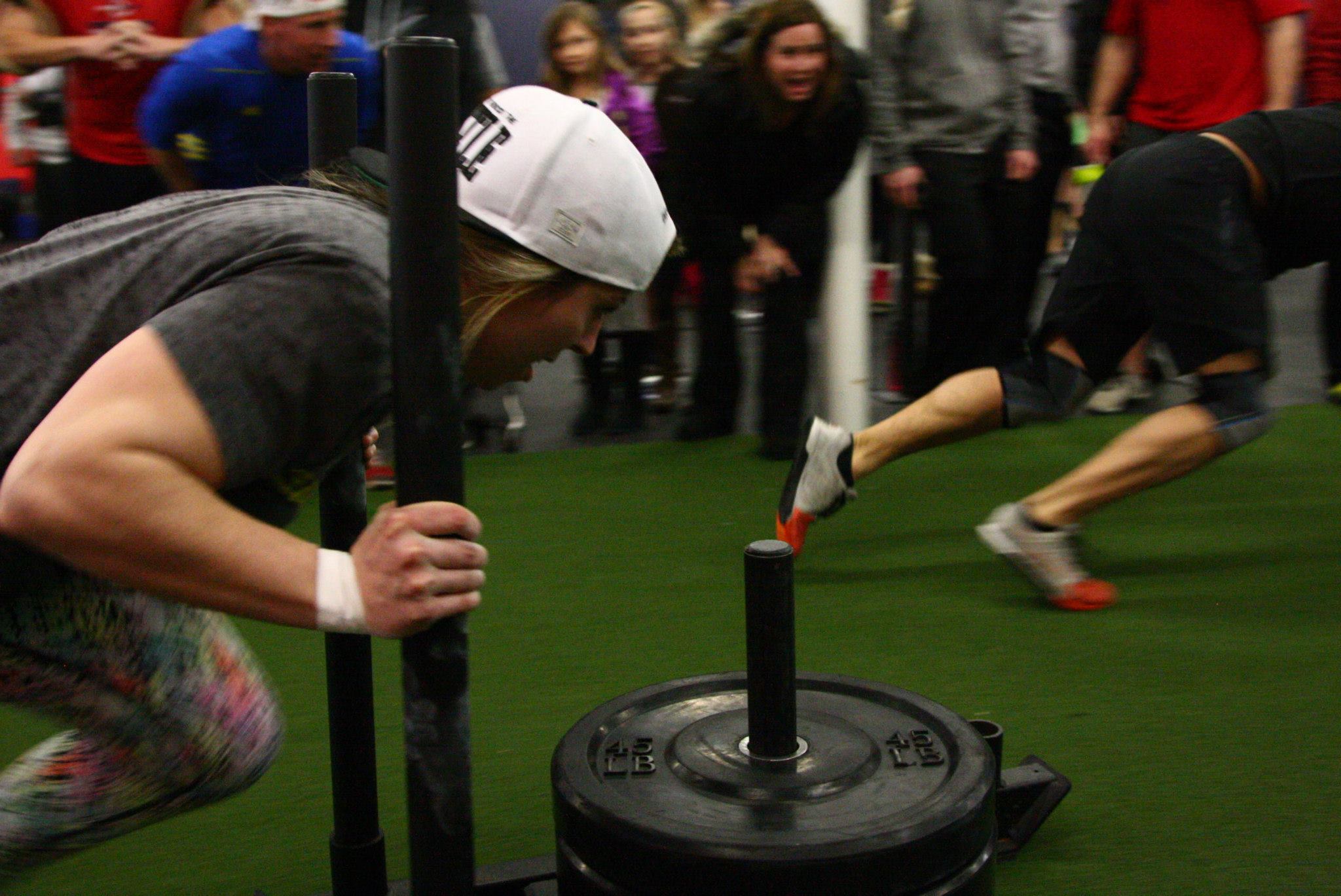 female first responder athlete pushing weighted sled
